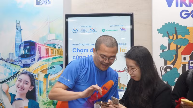Nhân viên Ngân hàng hỗ trợ hành khách làm thẻ đi Metro số 1 miễn phí tại các nhà ga trên hành trình. (Ảnh: Thế Anh) 