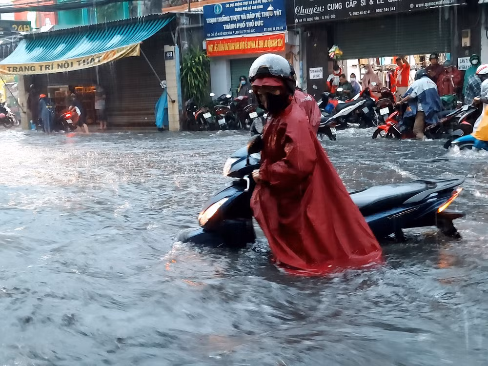 Người dân lội bì bõm, dắt xe trong cơn mưa chiều 15/5 khu vực đường Nguyễn Thị Rành, thành phố Thủ Đức
