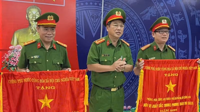 Thừa ủy quyền của Thủ tướng Chính phủ, Đại tá Trần Phòng, Phó Giám đốc Công an thành phố Đà Nẵng trao Cờ thi đua cho hai tập thể. (Ảnh: ANH ĐÀO)