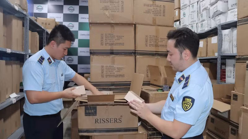 Lực lượng quản lý thị trường tỉnh Lạng Sơn hướng dẫn các hộ kinh doanh chấp hành quy định pháp luật trong kinh doanh, buôn bán. (Ảnh: LƯU QUYÊN)