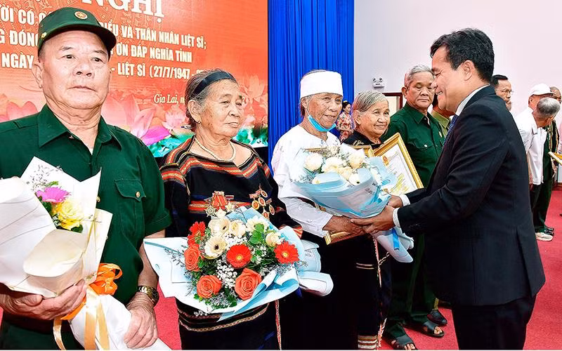Bí thư Tỉnh ủy Hồ Văn Niên tặng hoa, bằng khen cho các đại biểu người có công và thân nhân liệt sĩ. (Ảnh: Đức Thụy)