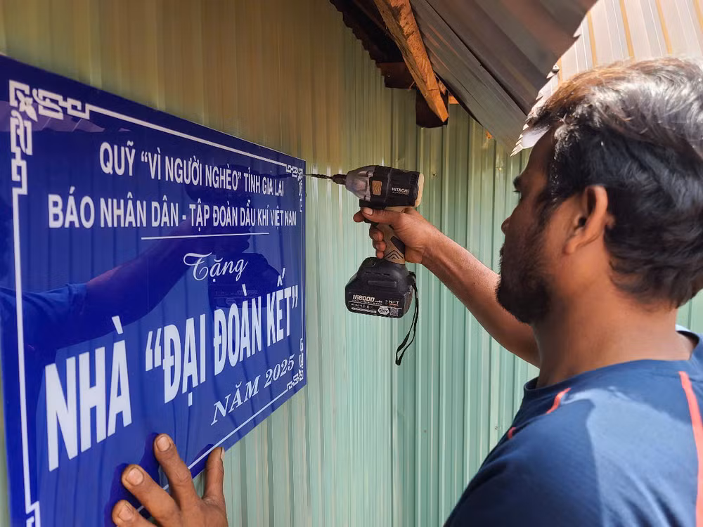 Bà con vui mừng gắn biển chuẩn bị cuộc sống mới trong ngôi nhà Đại đoàn kết.