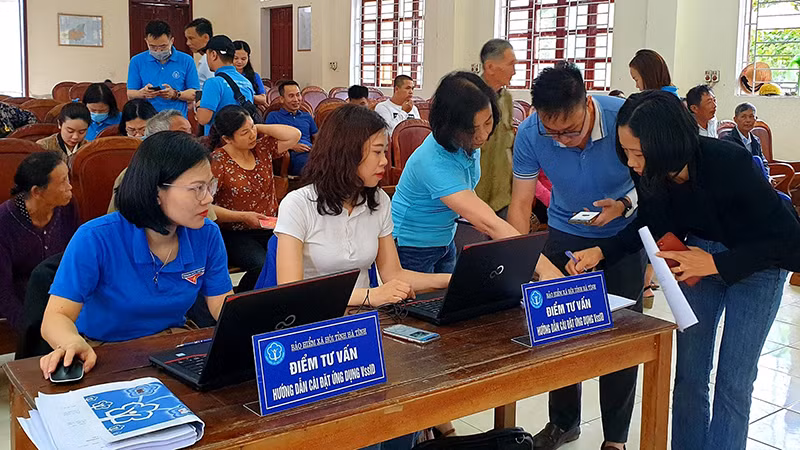 Cán bộ bảo hiểm xã hội hướng dẫn người dân cài đặt VssID. (Ảnh: Tâm Trung)