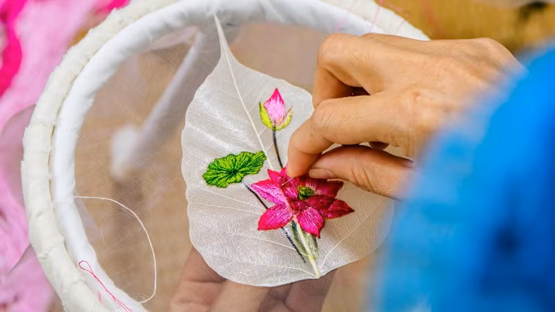 Việc thêu trên "xương lá" mỏng manh đòi hỏi kỹ thuật cao và sự kiên trì. Việc thêu trên "xương lá" mỏng manh đòi hỏi kỹ thuật cao và sự kiên trì.
