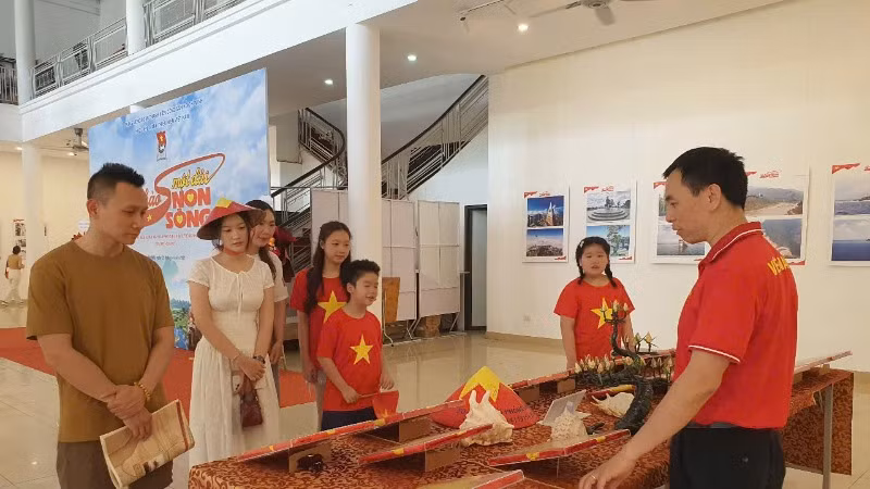 Tiến sĩ Nguyễn Việt Hùng, Giám đốc Bảo tàng Tuổi trẻ-Thư viện (bên phải) trực tiếp thuyết minh đến khách tham quan.