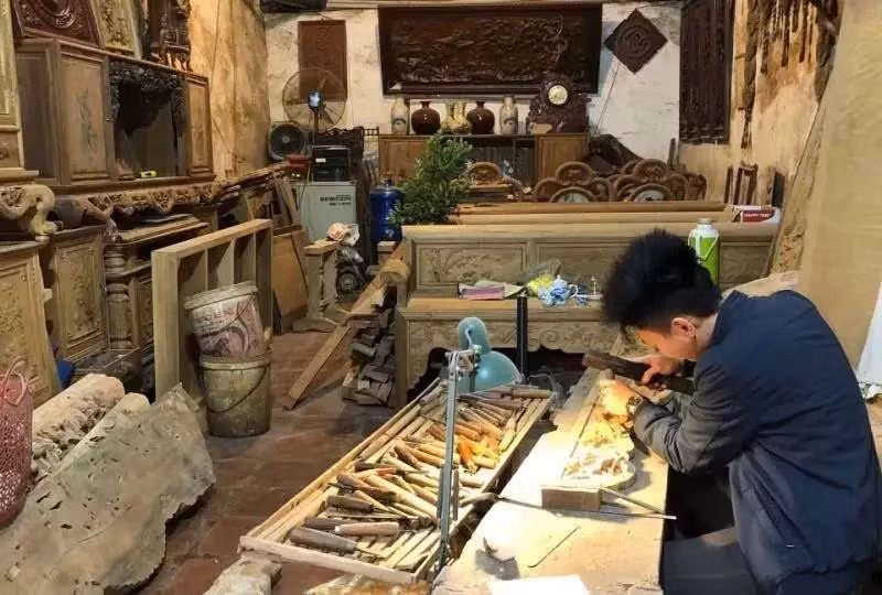 Người dân làng nghề Canh Nậu, huyện Thạch Thất chế tác đồ thờ bằng gỗ. (Ảnh: NGUYỄN PHƯƠNG)