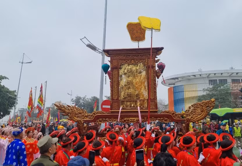 Người dân rước kiệu thánh ra sông Hồng làm lễ rước nước tại Lễ hội Đình Nhật Tân. (Ảnh: DIỆP VÂN)