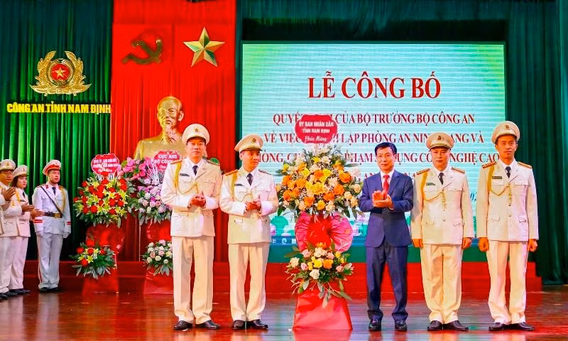 Đồng chí Phạm Đình Nghị, Chủ tịch UBND tỉnh Nam Định tặng hoa chúc mừng đại diện Phòng An ninh mạng và phòng, chống tội phạm sử dụng công nghệ cao thuộc Công an tỉnh.
