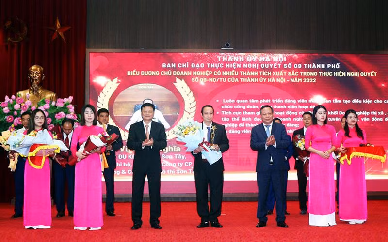 Lãnh đạo Thành ủy Hà Nội tặng hoa và biểu trưng cho các chủ doanh nghiệp có thành tích xuất sắc trong thực hiện Nghị quyết 09-NQ/TU. (Ảnh LƯƠNG TOÀN) 