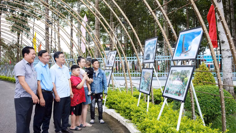 Người dân và chính quyền địa phương tham quan triển lãm ảnh. (Ảnh: HUỲNH LÃNH).
