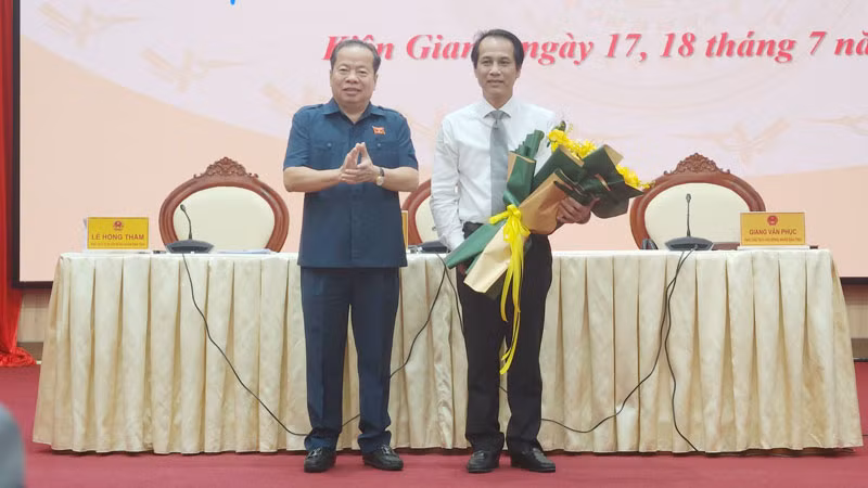 Chủ tịch Hội đồng nhân dân tỉnh Kiên Giang Mai Văn Huỳnh (bên trái) tặng hoa chúc mừng Giám đốc Sở Y tế tỉnh Kiên Giang Hồ Văn Dũng.