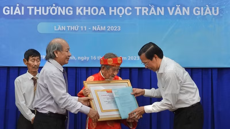 Chủ tịch Ủy ban nhân dân Thành phố Hồ Chí Minh Phan Văn Mãi (bên phải) và GS.TS.NGND Ngô Văn Lệ (thứ hai từ trái sang) trao giải thưởng cho nhà nghiên cứu Nguyễn Đình Tư. Chủ tịch Ủy ban nhân dân Thành phố Hồ Chí Minh Phan Văn Mãi (bên phải) và GS.TS.NGND Ngô Văn Lệ (thứ hai từ trái sang) trao giải thưởng cho nhà nghiên cứu Nguyễn Đình Tư.