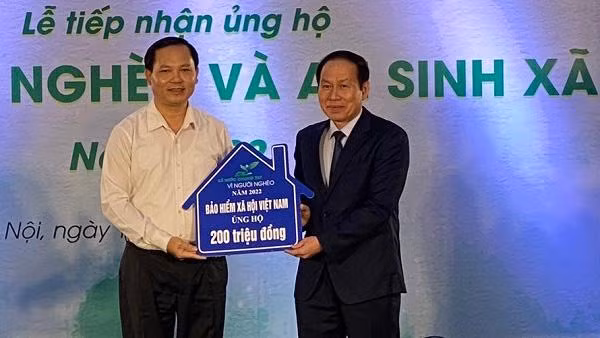 Phó Tổng Giám đốc Bảo hiểm xã hội Việt Nam Chu Mạnh Sinh (trái) trao 200 triệu đồng ủng hộ Quỹ Vì người nghèo năm 2022. (Ảnh: VSS)
