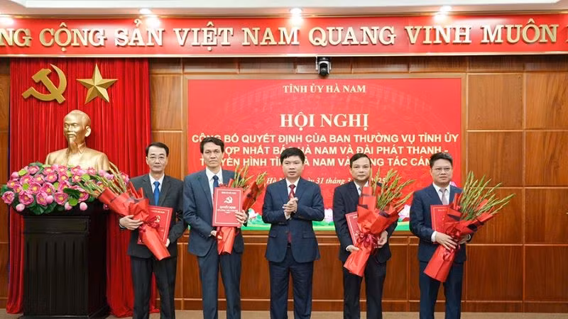 Đồng chí Trương Quốc Huy, Bí thư Tỉnh ủy, Chủ tịch Ủy ban nhân dân tỉnh, Trưởng Đoàn đại biểu Quốc hội tỉnh trao quyết định và tặng hoa chúc mừng Ban Biên tập Báo Hà Nam.