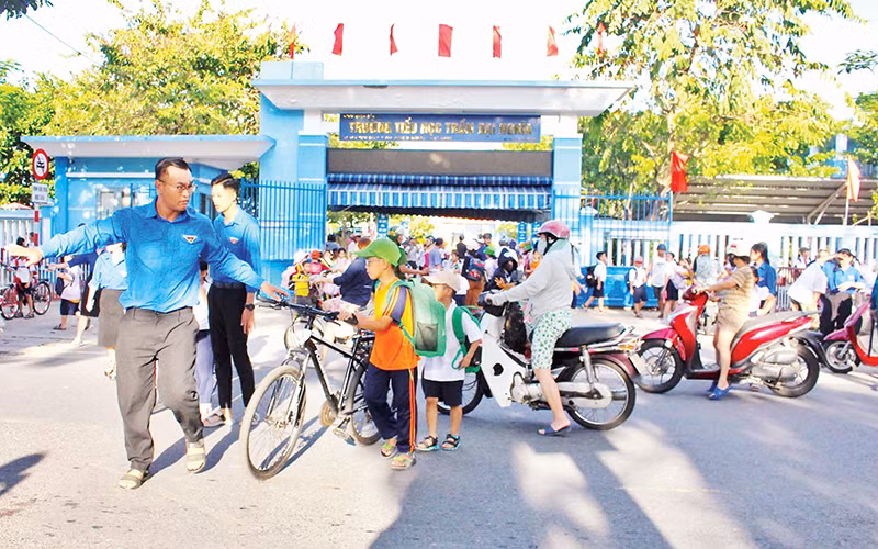 Đoàn viên, thanh niên giúp học sinh qua đường.