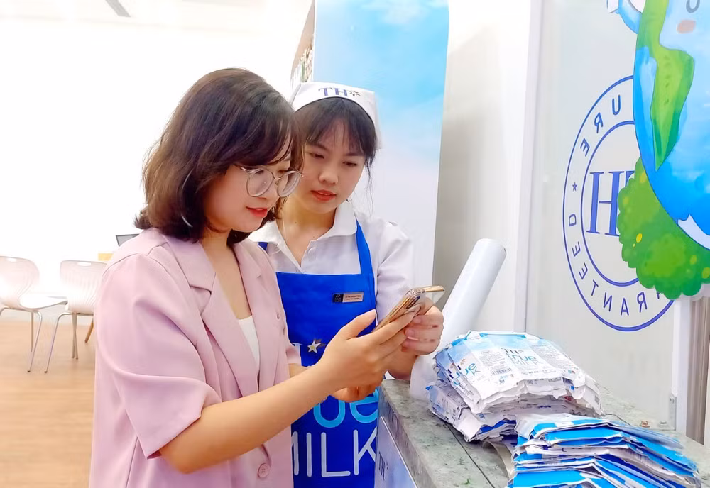 Chị Hiếu Ngân được nhân viên hướng dẫn quét mã quay thưởng khi đến TH true mart tham gia chương trình “Thu gom vỏ hộp, lan tỏa sống xanh 2024”.