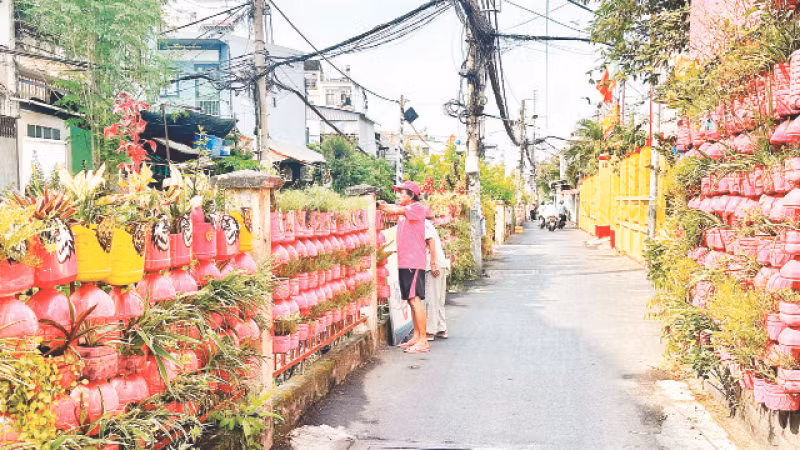 Người dân Phường 10, quận Phú Nhuận chăm sóc cây cảnh dọc tuyến đường nơi có đường sắt đi qua.