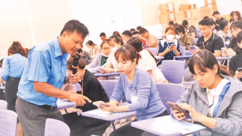 Cán bộ Liên đoàn Lao động tỉnh Bình Phước hướng dẫn công nhân, lao động tham gia cuộc thi trực tuyến tìm hiểu Nghị quyết Đại hội XIII Công đoàn Việt Nam và hành động của đoàn viên và người lao động.