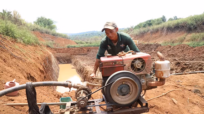 Nông dân Đắk Lắk thuê xe múc hố ngay dưới lòng hồ để tìm nước tưới cây trồng.