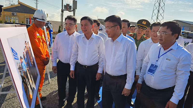 Phó Thủ tướng Lê Thành Long và các đại biểu tham quan ảnh giới thiệu về quá trình thực hiện dự án.