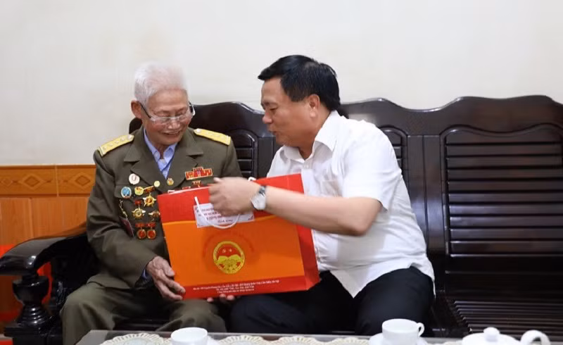 Đồng chí Nguyễn Xuân Thắng, Ủy viên Bộ Chính trị, Giám đốc Học viện Chính trị quốc gia Hồ Chí Minh, Chủ tịch Hội đồng Lý luận Trung ương, thăm, tặng quà ông Phạm Đức Cư là chiến sĩ Điện Biên.