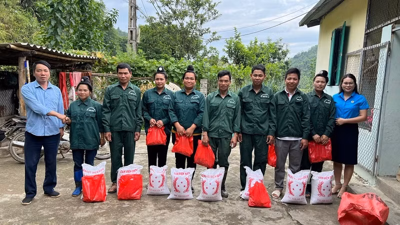 Cán bộ Nông trường cao-su Điện Biên trao quà Tết đến công nhân đội Hua Thanh.