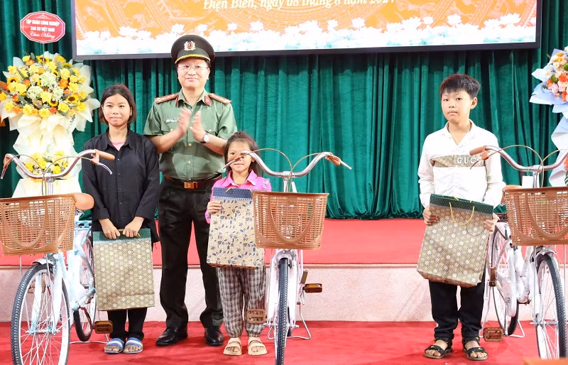 Đại tá Nguyễn Thanh Bình, Phó Cục trưởng Cục Xây dựng phong trào "Toàn dân bảo vệ an ninh Tổ quốc" Bộ Công an tặng quà các cháu học sinh là con em công nhân Công ty cổ phần cao-su Điện Biên.