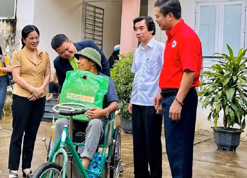 Đại diện các đơn vị tặng quà, thăm hỏi một hộ dân nhận quà tại chương trình.