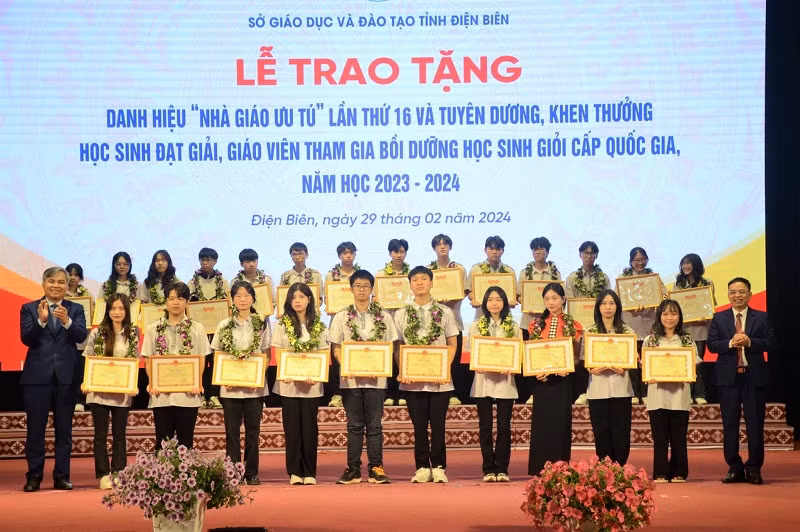 Đồng chí Lò Văn Tiến, Phó Chủ tịch Ủy ban nhân tỉnh và đồng chí Nguyễn Văn Đoạt, Giám đốc Sở Giáo dục và Đào tạo tỉnh Điện Biên tặng hoa, chúc mừng các em học sinh đoạt giải học sinh giỏi quốc gia, năm học 2023-2024.