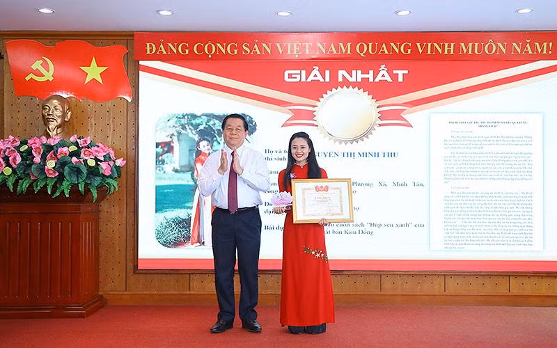 Đồng chí Nguyễn Trọng Nghĩa trao giải nhất Cuộc thi tặng thí sinh Nguyễn Thị Minh Thu. 