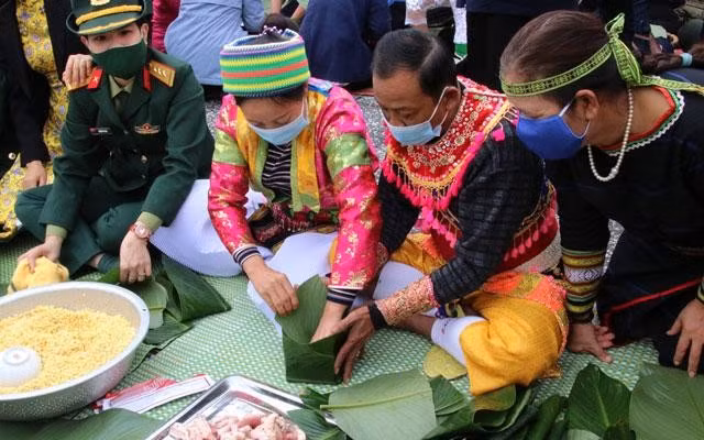 Đồng bào dân tộc cùng các chiến sĩ tham gia Chương trình gói "Bánh chưng xanh" tại Làng. (Ảnh: Làng Văn hóa-Du lịch các dân tộc Việt Nam)