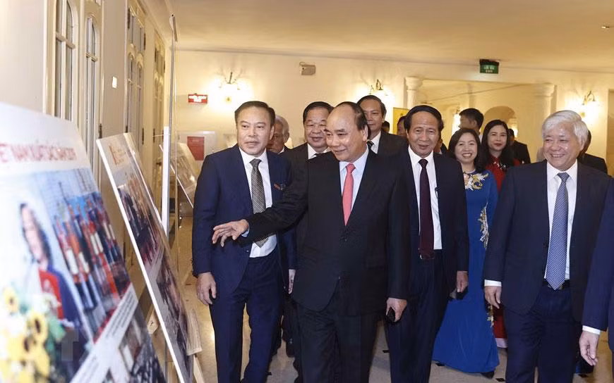 Chủ tịch nước Nguyễn Xuân Phúc và các đại biểu xem trưng bày ảnh tại buổi lễ.