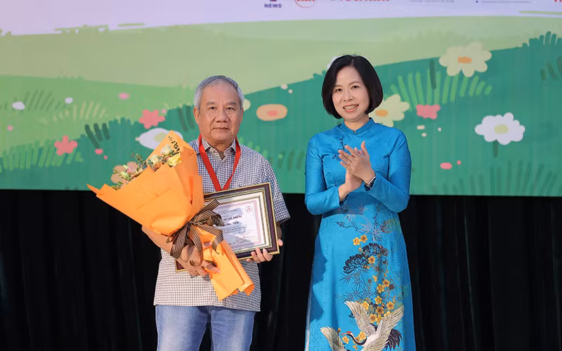 Tổng Giám đốc Thông tấn xã Việt Nam Vũ Việt Trang trao giải Hiệp sĩ Dế Mèn cho nhà văn Trần Đức Tiến. (Ảnh: Ban tổ chức)