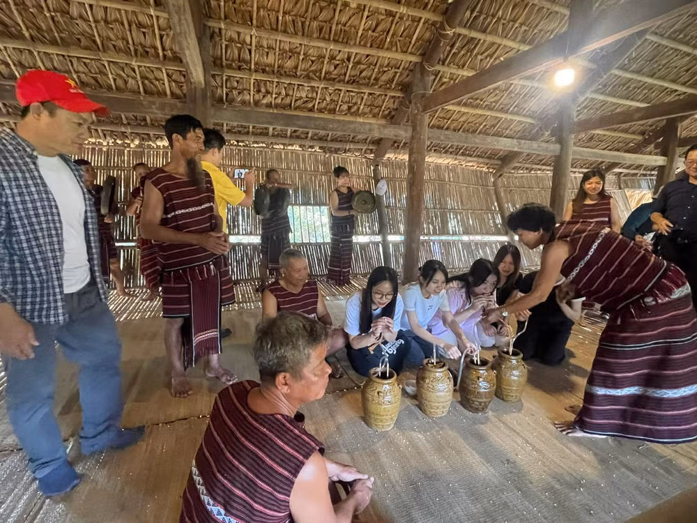 Du khách trải nghiệm uống rượu cần với bà con Chơ ro (Đồng Nai).