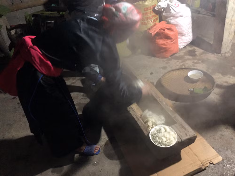 Gạo nếp đồ xong được đổ ra cối gỗ.