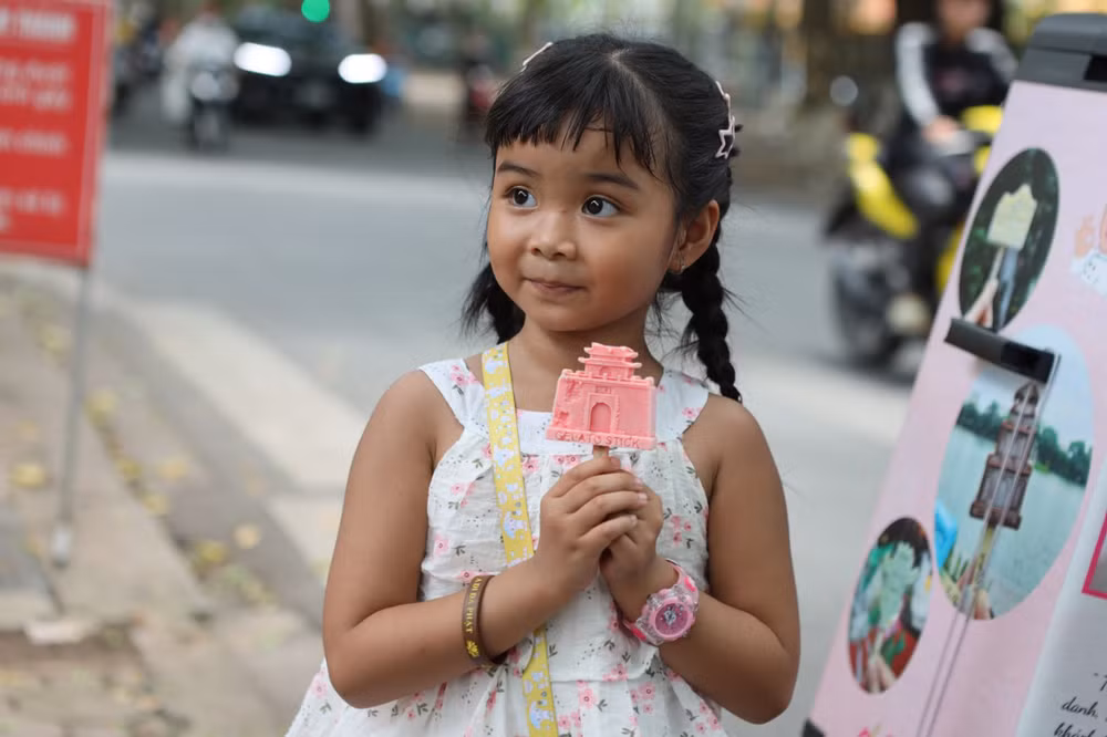 Em nhỏ thích thú với cây kem hình di tích Cửa Bắc. Em nhỏ thích thú với cây kem hình di tích Cửa Bắc.