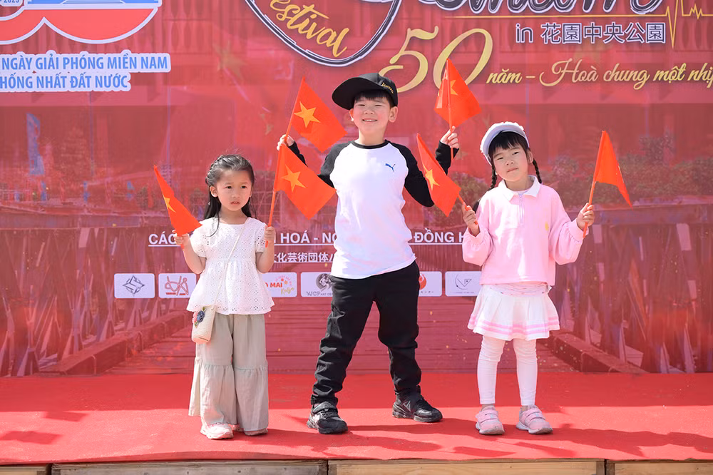 Các em bé hào hứng với lá cờ đỏ sao vàng.