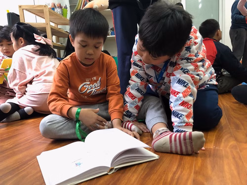 Hai em nhỏ đang đọc cuốn "Trò chơi của trẻ em ở Bắc Kỳ”. Hai em nhỏ đang đọc cuốn "Trò chơi của trẻ em ở Bắc Kỳ”.