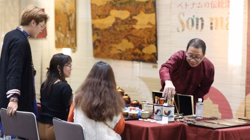 Họa sĩ Lương Minh Hòa hướng dẫn khách khắc, thếp bạc, mài để tạo nên một bức sơn mài khắc làm kỷ niệm. (Ảnh: Bộ Ngoại giao Việt Nam)