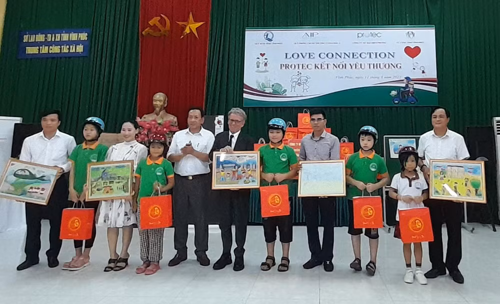 Các nhà tài trợ tặng quà, mũ bảo hiểm cho trẻ em đặc biệt khó khăn.