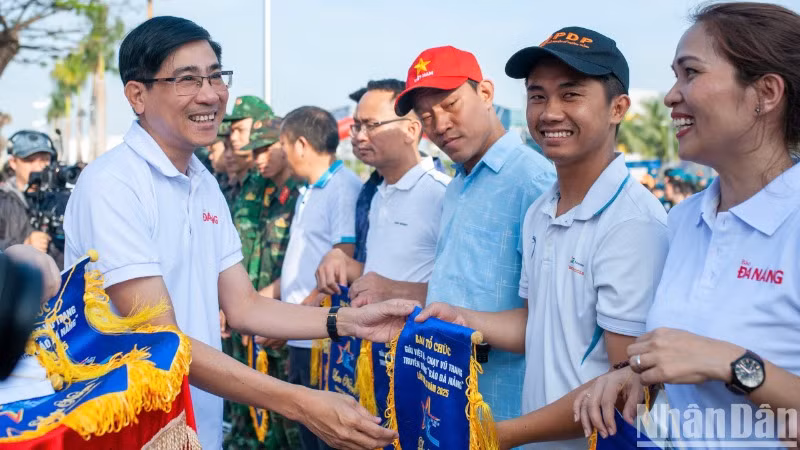 Trao cờ lưu niệm cho các đơn vị tham gia Giải Việt dã - chạy Vũ trang truyền thống Báo Đà Nẵng lần thứ 28.