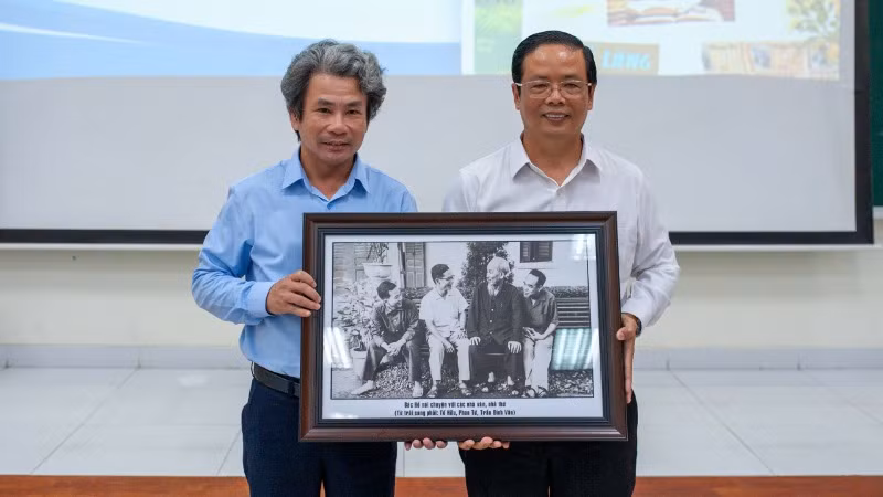 Đại diện gia đình nhà văn Phan Tứ trao quà lưu niệm cho Trường đại học Sư phạm Đà Nẵng.