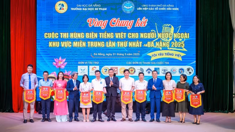 Ban tổ chức trao cờ lưu niệm cho các đội thi.