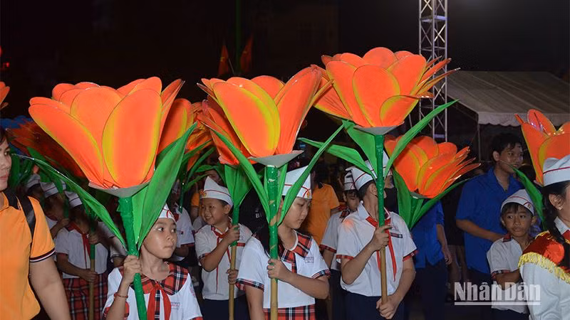 Học sinh trường tiểu học, THCS và THPT Lê Quý Đôn rước lồng đèn nhỏ với hình ảnh logo năm Du lịch quốc gia 2023 “ Bình Thuận - Hội tụ xanh”.