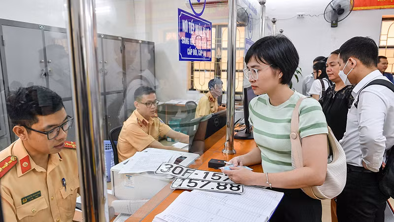 Người dân làm thủ tục cấp biển số định danh tại Cơ sở đăng ký xe số 2, phường Láng Thượng, quận Ðống Ða, Hà Nội. (Ảnh THÀNH ÐẠT)