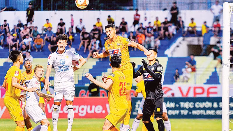 Pha tranh bóng giữa hai đội Thép Xanh Nam Ðịnh (áo trắng) và Ðông Á Thanh Hóa. (Ảnh VPF) 