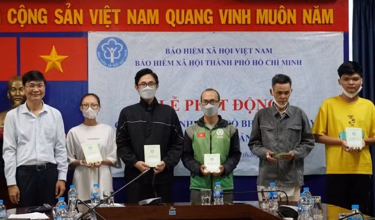 Trao thẻ bảo hiểm y tế, sổ bảo hiểm xã hội cho người dân có hoàn cảnh khó khăn, diện chính sách trên địa bàn Thành phố Hồ Chí Minh. (Ảnh: HSS)