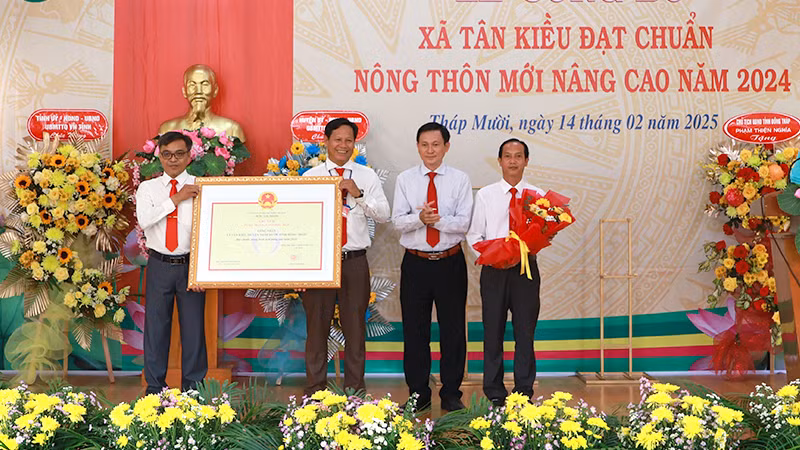 Phó Chủ tịch Hội đồng nhân dân tỉnh Đồng Tháp Kiều Thế Lâm trao bằng công nhận xã Tân Kiều đạt chuẩn nông thôn mới nâng cao. (Ảnh: HOÀNG KHA)