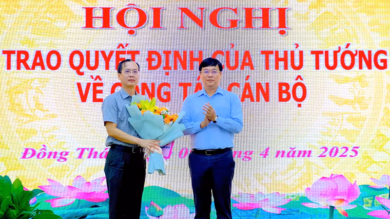 Ủy viên Trung ương Đảng, Bí thư Tỉnh ủy Đồng Tháp Lê Quốc Phong trao quyết định của Thủ tướng Chính phủ cho ông Trần Trí Quang và tặng hoa chúc mừng. (Ảnh: NHƯ ANH)