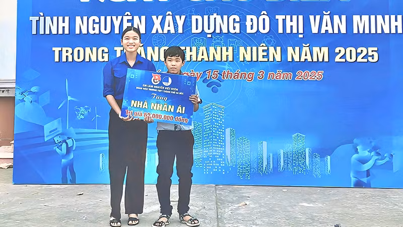 Em Lâm Nguyễn Việt Uyên trao bảng tượng trưng cho em Lý Thiện Đức. (Ảnh: TRUNG THÀNH)